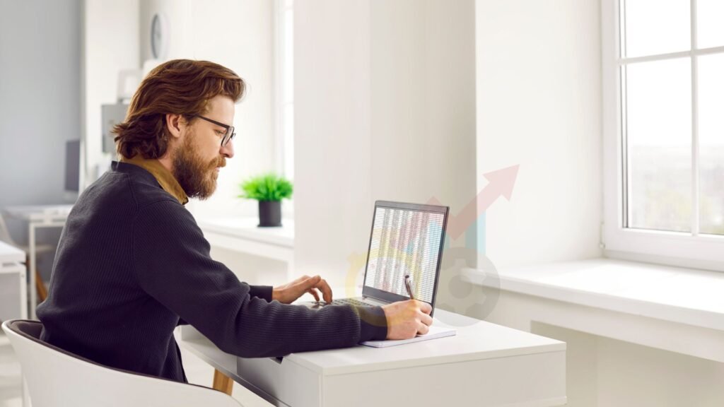 an image of a man working on an excel file on his laptop